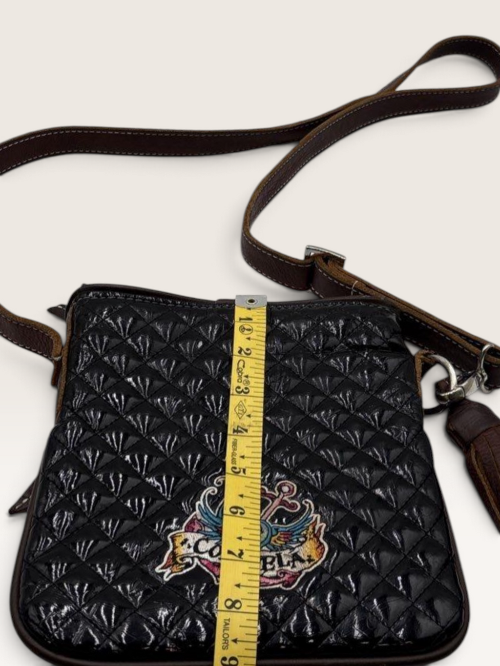 Consuela Black Quilted Crossbody Bag with Embroidered Logo & Tassel